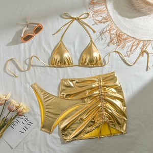 Detailed macro view of gold metallic three-piece bikini set with side drawstring skirt