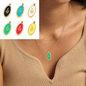 Detail of colorful enamel snake pendants on gold necklaces worn by a model