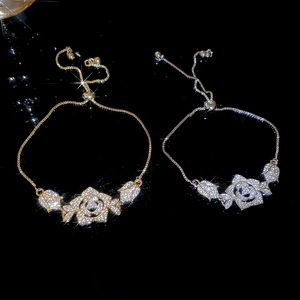 Close-up of adjustable gold and silver rose bracelets with shimmering zircon inlay