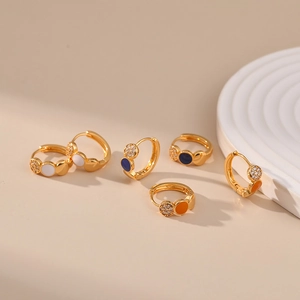 18K gold plated hoop earrings with enamel dots and zircons on a warm beige backdrop