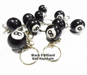 Macro view of several black billiard number 8 resin keychains stacked on white background