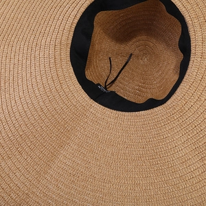 Detail view of the straw hat interior with adjustable drawstring and black sweatband