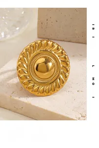 Macro shot of gold retro ring featuring relief sunburst texture on a stone background