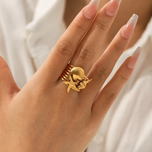 18k vergoldeter Edelstahl Seestern Muschel Ring getragen von einem Modell am Finger
