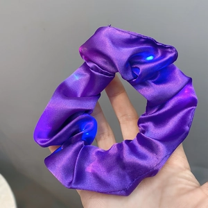 Detail of purple satin scrunchie with glowing blue LED lights for night hair styling