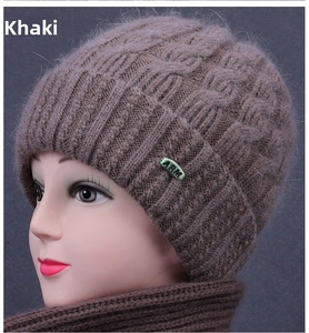 Detailed knit texture of khaki winter hat with braided pattern and metal logo plate