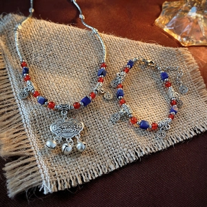 Macro shot of a vintage long life lock pendant with red beads on a linen background