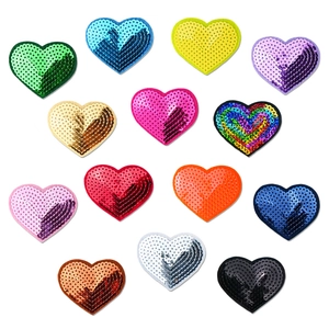 Macro shot of 14 colorful heart-shaped sequin patches for DIY garment decoration