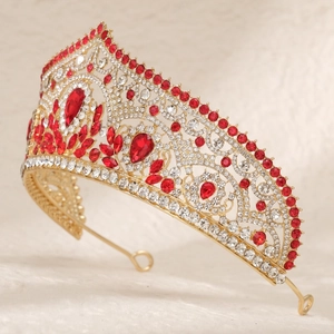 Macro detail of golden bridal tiara featuring red and clear rhinestones on metal frame