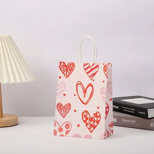 Pink Valentine's Day gift bag with printed heart patterns and white rope handles