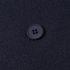Macro shot of stylish navy wool jacket featuring classic round buttons and textured fabric