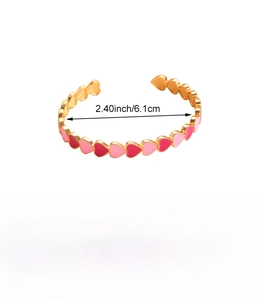 Dettaglio del bracciale rigido a cuore smaltato rosso e rosa con diametro 6,1 cm e peso
