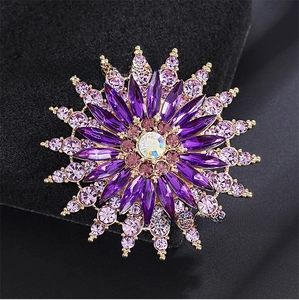 Macro detail of sunburst brooch with purple crystals and rainbow aurora main stone