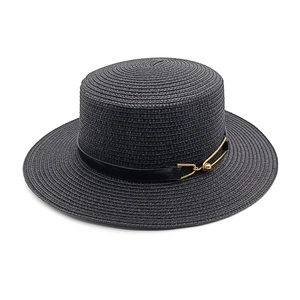 Close-up of black straw flat top hat featuring a leather band with gold buckle detail