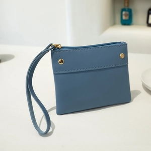 Minimalist light blue faux leather coin purse with wrist strap and gold stud detail