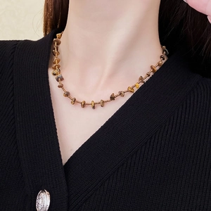Maillard brown tiger eye stone beaded necklace with gold accents worn by a model