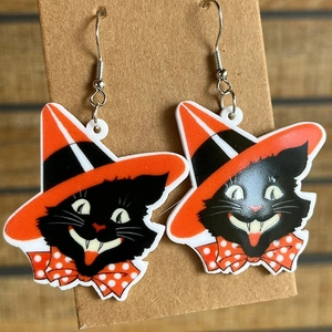 Close-up of Halloween black cat earrings with orange wizard hat on display card