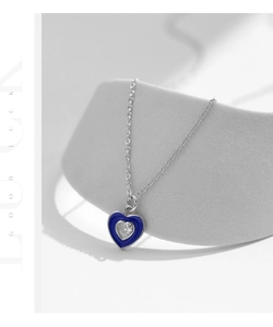 Macro shot of silver heart necklace with Klein blue enamel and sparkling center zircon