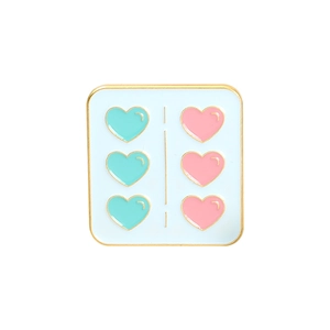 Detail of square enamel pin featuring six teal and pink hearts with golden trim
