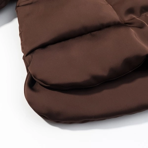 Vue détaillée du tissu matelassé marron et de l'ourlet de cette doudoune courte femme