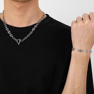 Close-up of silver pig nose chain necklace and bracelet set with OT buckle on male model