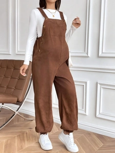 Adjustable brown corduroy maternity overalls styled with long sleeve shirt and sneakers