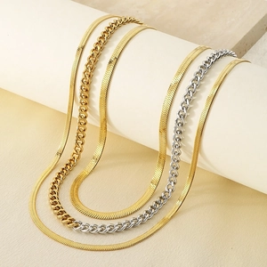 Detail of layered gold snake chain and mixed gold and silver Cuban link necklaces