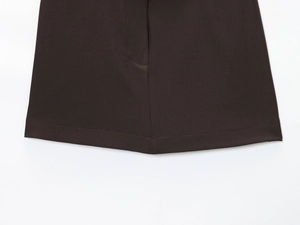 Détail des coutures précises et du tissu marron foncé de l'ensemble short et blazer