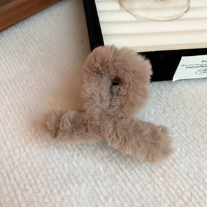 Detail shot of light brown fluffy plush hair claw clip with warm faux fur texture