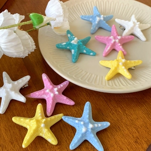 Close-up of starfish hair clips in multiple colors with realistic resin texture details