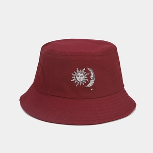 Dettaglio di un cappello da pescatore bordeaux con ricamo sole e luna su tessuto pregiato