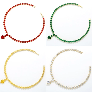 Detail of colorful heart gemstone necklaces in red green yellow and white with gold chain
