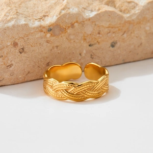 Adjustable golden stainless steel braided twist ring on a natural stone background