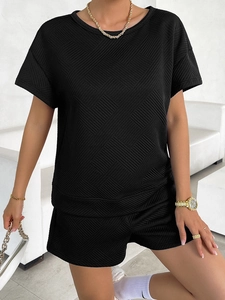 Detailed view of women's black knit set showing the unique diamond texture fabric
