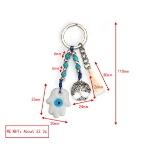Detailed view of Evil Eye keychain with Hamsa hand, Tree of Life charm and white tassel