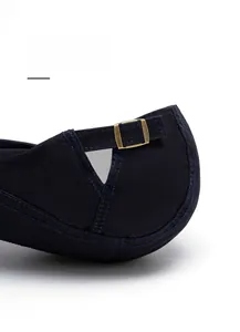 Detail of adjustable metal buckle and navy twill fabric on the back of the newsboy cap