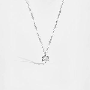 Macro view of a classic six-prong silver necklace featuring a brilliant single zircon stone