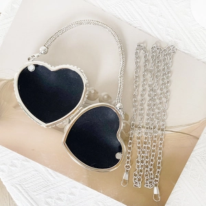 Detail view of mini heart-shaped silver evening bag with sparkling rhinestones and chains