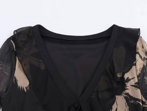Detail of V-neckline with brushstroke print, mesh fabric, and ruffle shoulder accents