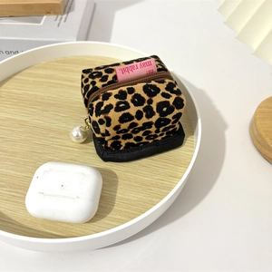 Detail view of leopard print corduroy earphone pouch with gold zipper and pearl charm