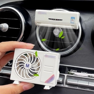 Mini white car air conditioner model aromatherapy diffuser on dashboard air vent