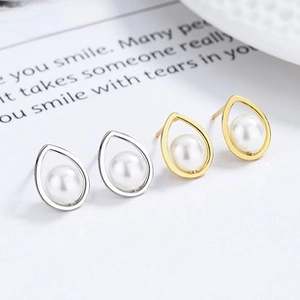 Detail of silver and gold teardrop pearl earrings displayed on minimalist aesthetic cards