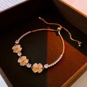 Adjustable gold clover bracelet with synthetic opal flowers and sparkling cubic zirconia