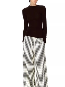 Slim-fit black wool-tencel long-sleeve top paired with stylish striped trousers