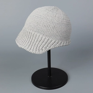 Close-up of light gray knitted aviator hat showing thick texture and peak detail