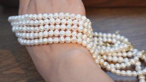 Detail of multi-layer white freshwater pearl bracelet on a model wrist with soft luster