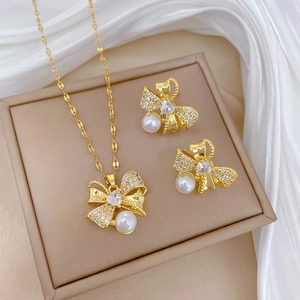 Macro view of bowknot jewelry set with rhinestones and pearl on silk fabric