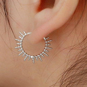 Close-up of S925 silver hoop earring with sunburst design on model ear