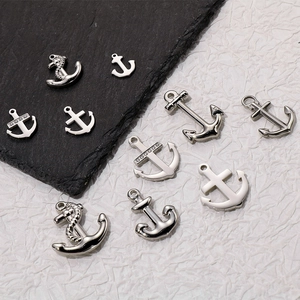 Detailed macro view of assorted silver stainless steel anchor pendants with rope details