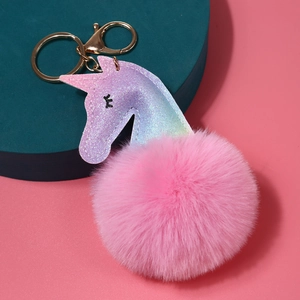 Detalle de llavero de unicornio con purpurina, pompón de peluche rosa y enganche dorado